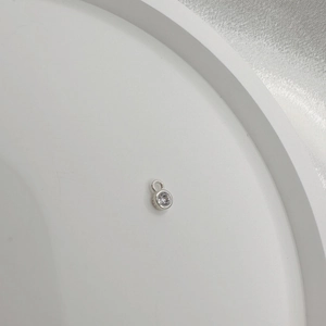 Macro shot of minimalist S925 sterling silver round pendant with cubic zirconia inlay