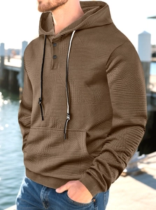 Detail of men's brown hoodie featuring geometric texture, button neck and drawstring hood