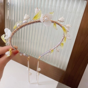 Detailed close-up of handmade floral headband with white flowers and pearls