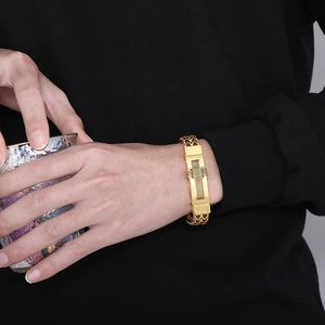 Macro detail of men's gold plated stainless steel mesh chain bracelet with metal plate