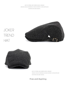 Detail of dark grey wool newsboy cap showing metal buckle and textured fabric