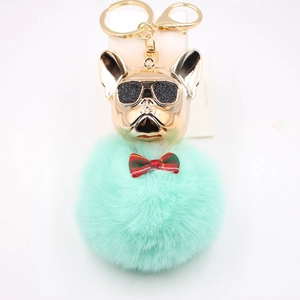 Dettaglio portachiavi bulldog con pompon verde menta, fiocco a quadri e finiture dorate