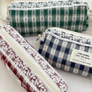 Detail of three checkered pouches featuring floral lace trim and vintage fabric labels