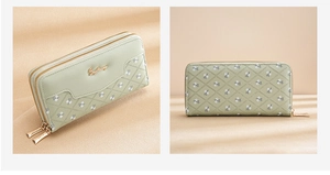Close-up of light green floral women's wallet with dual zippers and metal logo