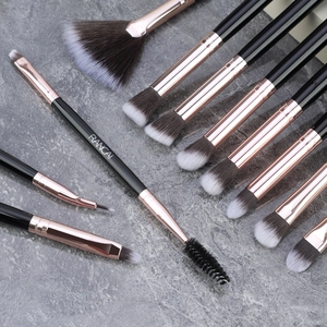 Detail view of professional black and rose gold makeup brushes on marble background
