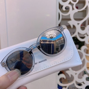 Close-up of kids' gray-blue sunglasses with a textured white leather case and dark lenses