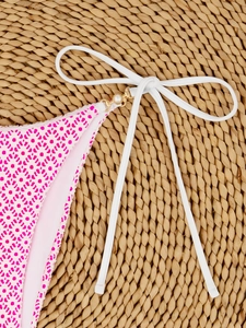 Detail of pink floral bikini bottom with side tie and elegant gold pearl buckle