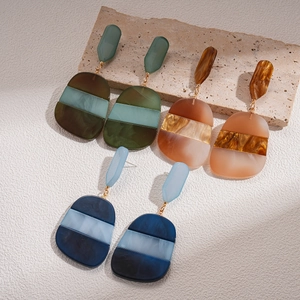 Three pairs of geometric oval acetate earrings in blue green and amber shades