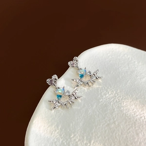 Macro shot of silver heart stud with irregular star pendant and blue opal stone