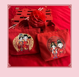 Detail of red wedding canvas gift bags featuring traditional Chinese bride and groom motifs
