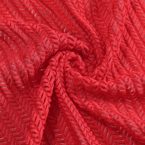 Close-up detail of red breathable knit mesh fabric with wave herringbone texture pattern