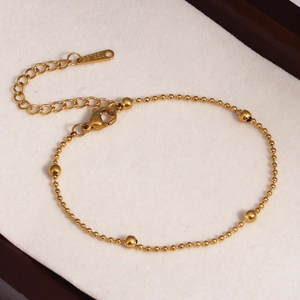 Détails d'un bracelet doré en acier inoxydable à perles avec fermoir mousqueton réglable