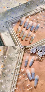 Detail of vintage nail stickers with blue ribbon bows, gold crowns and embossed butterflies