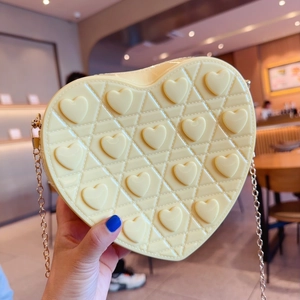 Detailed view of heart-shaped yellow jelly bag with 3D embossed hearts and gold chain
