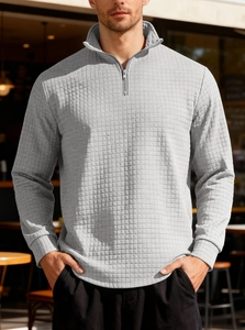 Detailed view of grey waffle textured fabric and ribbed cuffs on men's half-zip sweatshirt