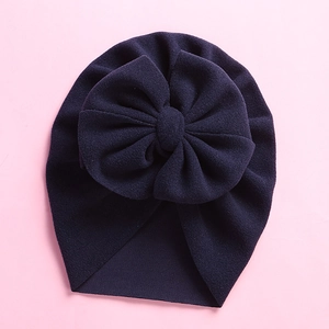 Detail of navy blue baby turban hat with oversized bow and soft knit texture