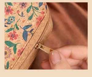 Detail of floral cork jewelry organizer featuring a smooth golden metal zipper closure