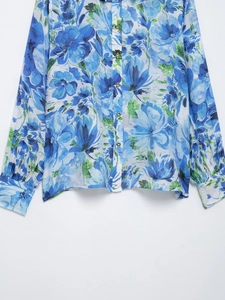 Close-up of blue floral print shirt with long sleeves and elegant button-down detail