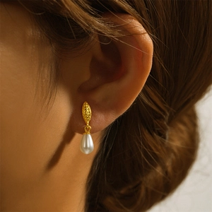 Close-up of vintage s925 silver hoop earring featuring teardrop pearl and hammered metal