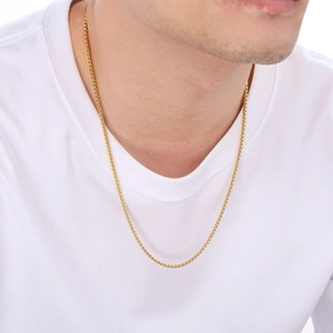 Detail of 3mm gold box chain necklace worn by male model on a white round neck t-shirt