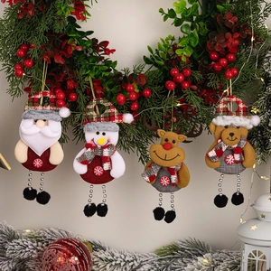 Details von Plüsch-Weihnachtsanhängern mit Perlenbeinen an einem festlichen Beerenkranz