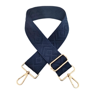 Detail of 5cm wide navy blue bag strap with geometric embroidery and gold metal clips