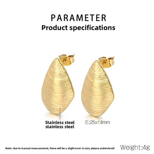 Macro detail of golden teardrop earrings with fine brushed texture and stainless steel finish