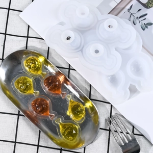Dettaglio dello stampo in silicone a forma di pesce con creazioni in resina sul tavolo