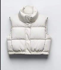 Flat lay of a white cropped puffer vest featuring a stand collar and quilted texture