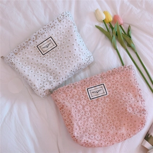 Detailed texture of daisy lace embroidery on white and pink handbags with zipper