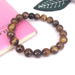 Primer plano de pulsera con cuentas de ojo de tigre de 10mm y textura ojo de gato marrón