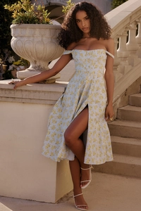Detailed view of the side slit and light blue floral print on this elegant midi dress