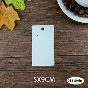 White 5x9cm jewelry display cards for earrings and studs on a wooden background