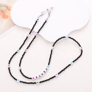 Detail of black seed beads eyewear chain with PEACE lettering on a white background