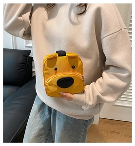 Close-up of a yellow cartoon puppy canvas bag with 3D ears and black handle straps