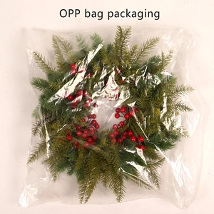Close-up of artificial Christmas wreath with red berries in OPP bag packaging