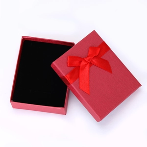 Detailed shot of a red textured jewelry gift box with a silk ribbon bow and black lining