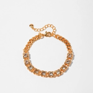 Detailed close-up of golden bracelet featuring square zircon stones and lobster clasp