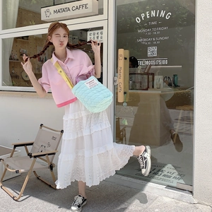 Street style shot of light blue quilted heart crossbody bag with sweet pastel outfit