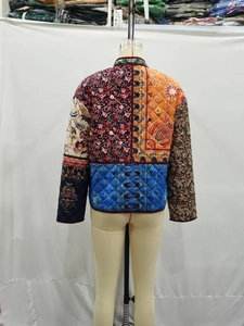 Quilted jacket detail featuring ethnic floral patchwork and intricate paisley patterns