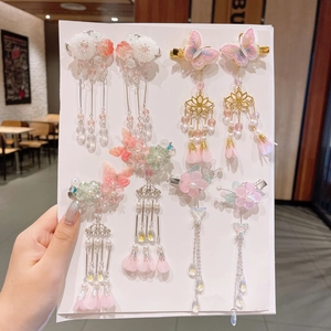 Detail of ancient style hair clips with pink resin flowers and dangling tassels