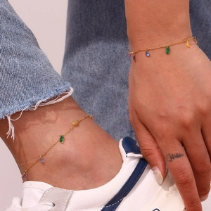 Detail of 18K gold plated chain with colorful zircon gems worn as a bracelet and anklet