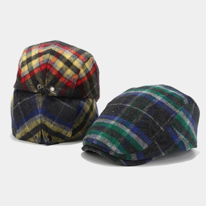 Detailed close-up of wool plaid newsboy caps with vintage check patterns and metal snap buttons