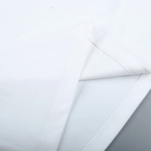 Detail view of double-stitched hem on white cotton dress showing fine sewing craftsmanship
