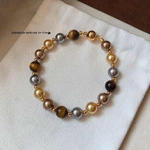 Détail d'un bracelet en œil de tigre pour poignet 14-17 cm sur tissu blanc