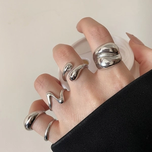 Close-up of liquid silver style geometric rings set with polished metallic finish