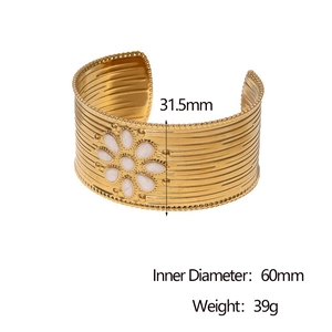 Detail view of 31.5mm wide 18k gold-plated cuff bangle with white floral pattern