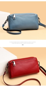 Detail view of blue and red lychee grain leather crossbody bags with zipper and metal buckle