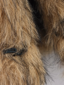 Detailopname van luxe imitatiebont vest met dikke bruine en zwarte lange pluche textuur