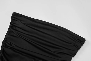 Close-up of elegant black ruched fabric detailing on a sexy summer bodycon dress